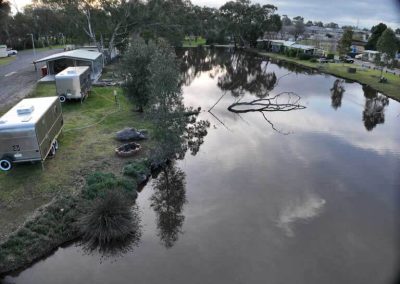 Aerial view of two retro vans positioned by the lakeside at Stawell Grampians Gate C&C Park – one of the Cabins, Dwellings, Caravans, & Glamping Tents available.
