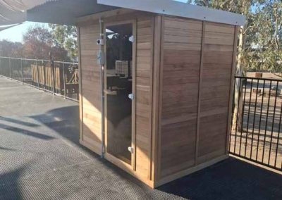 Outdoor sauna cabin with glass door and wood paneling on a raised platform at Stawell Grampians Gate C&C Park accommodation.