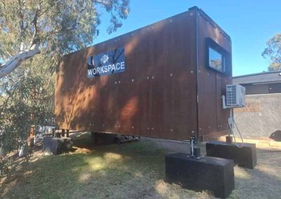 Modern workspace cabin elevated on stilts with air conditioning and branded signage located in Stawell Grampians Gate C&C Park.