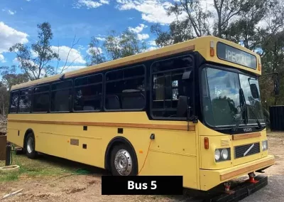 Vintage yellow Volvo bus converted into unique holiday accommodation, parked lakeside at Stawell C&C Park.