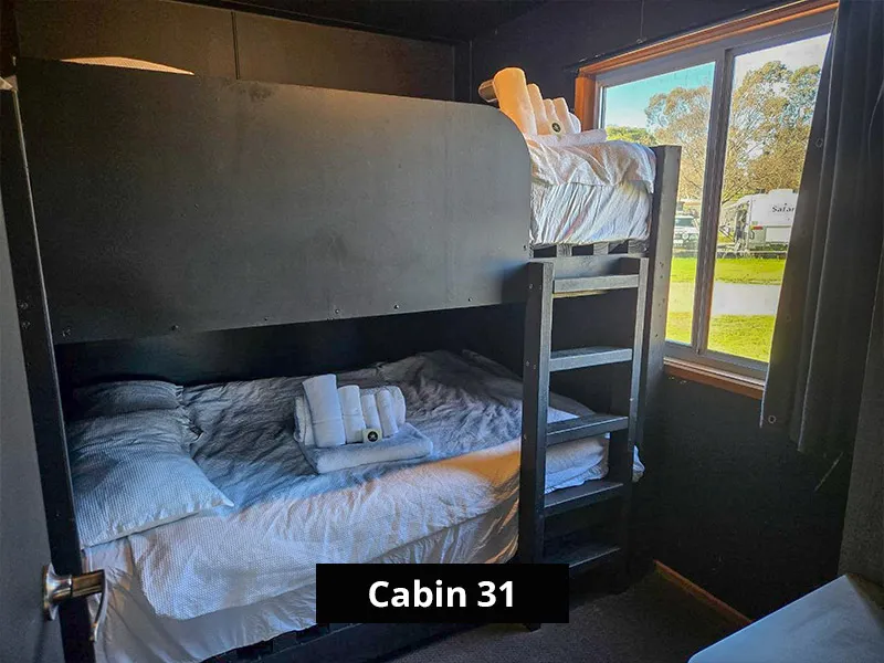 Second bedroom in Cabin 31 with modern black-frame bunk beds, perfect for families or groups visiting the Grampians region.