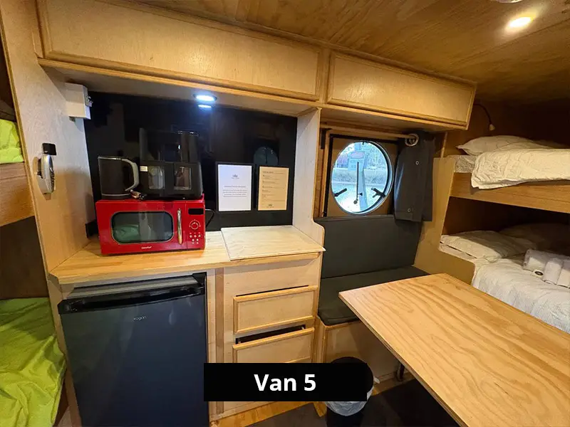 Caravan kitchenette with microwave, mini fridge, storage drawers and compact dining area